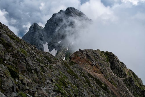 雲が沸き立つ吊尾根の登山道の写真