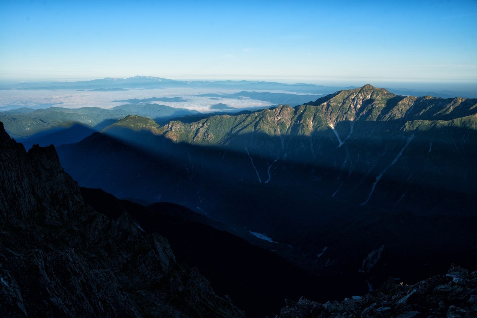「穂高から伸びる影と笠ヶ岳」の写真