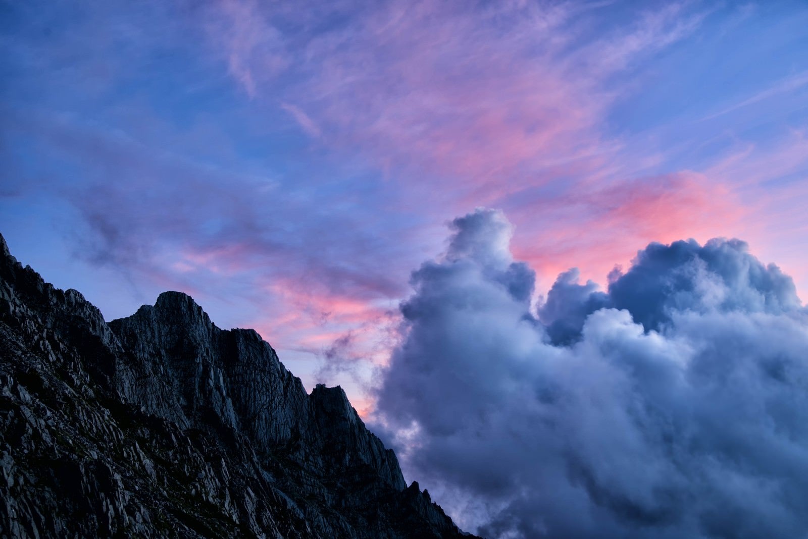 「焼けた空に沸き立つ積雲とジャンダルムの岩峰」の写真