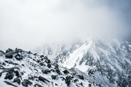 ガスに覆われる穂高連峰の稜線の写真