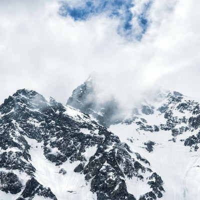 沸き立つ雲に見え隠れする前穂高岳（北アルプス）の写真