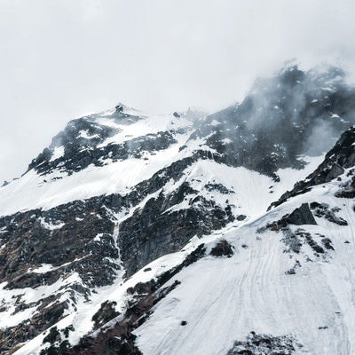 断崖にかかる雲と奥穂高岳（飛騨山脈）の写真