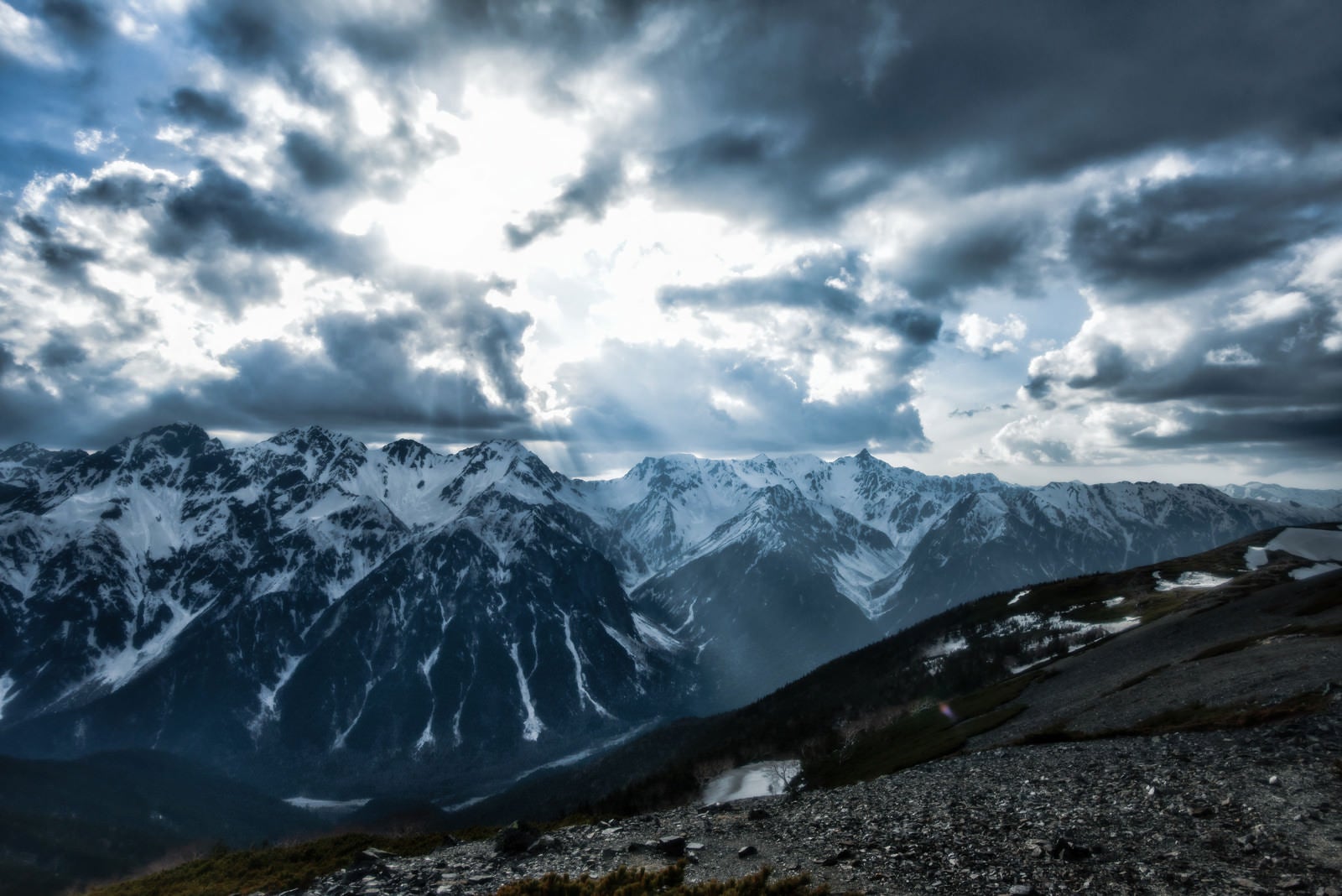 「雲間から降り立つ天使のはしごと飛騨山脈」の写真