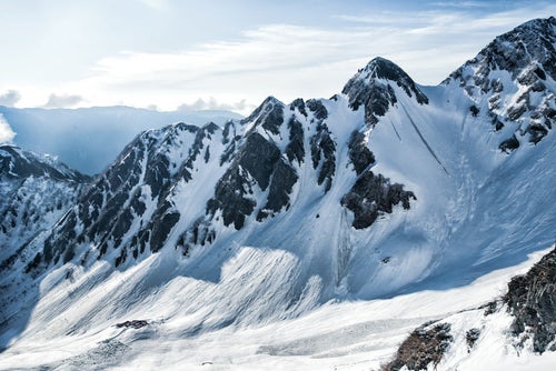 雪で覆われた涸沢ヒュッテと前穂高岳北尾根（北アルプス）の写真