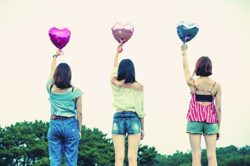 ハートの風船を掲げる女子三人組の写真