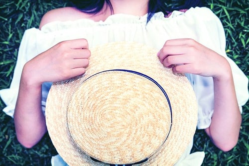 麦わら帽子を抱える女子の写真