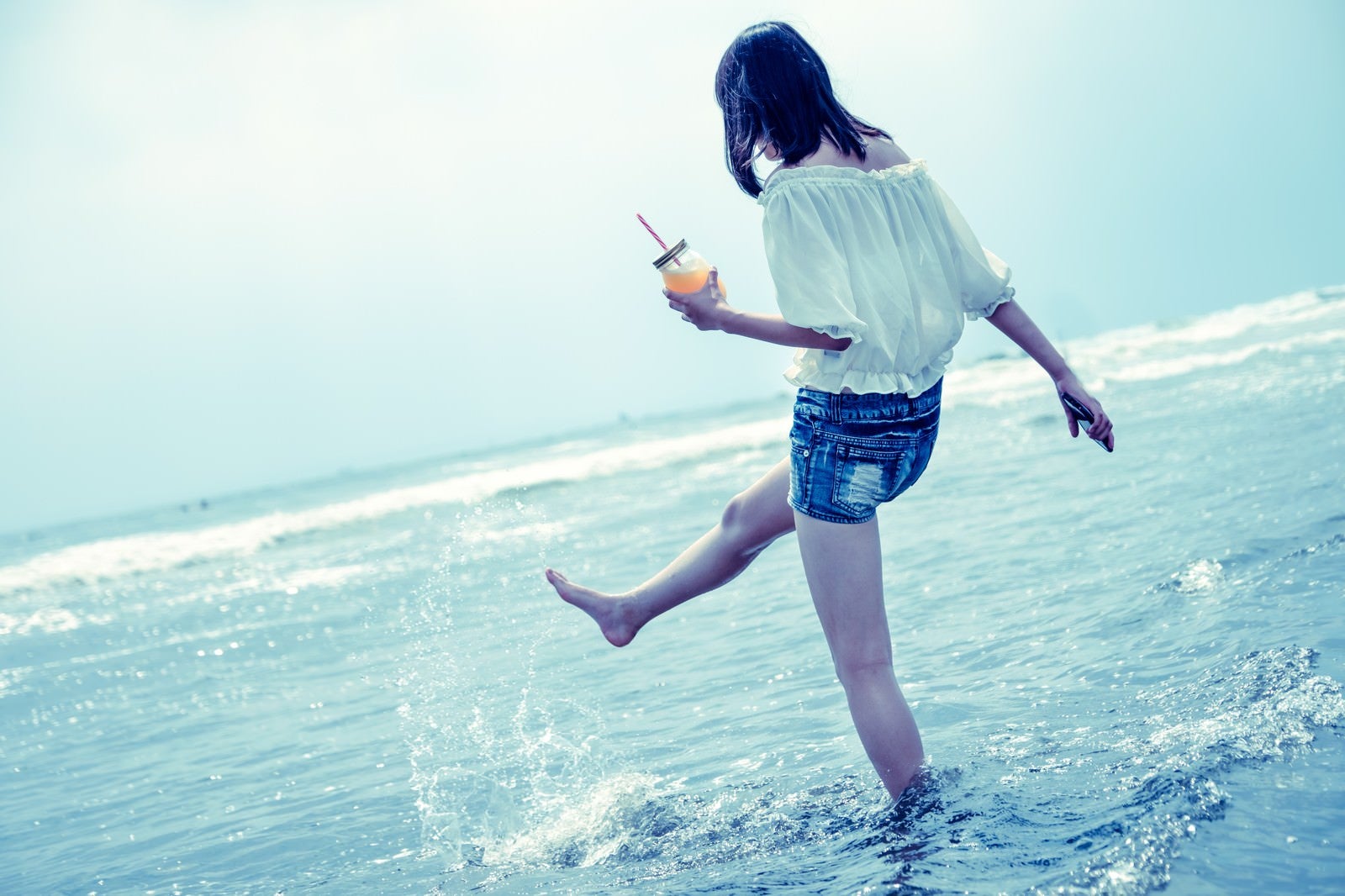 「海面を蹴り上げる女性」の写真