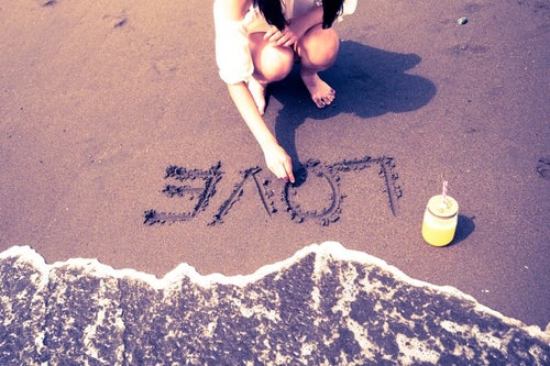 砂浜に書いたLOVEの文字の写真