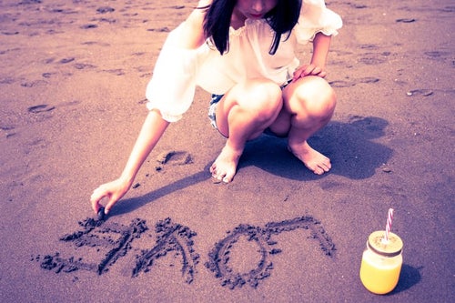 砂浜に「LOVE」を書く女の子の写真