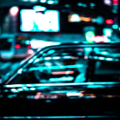 ネオンを反射するタクシーの写真