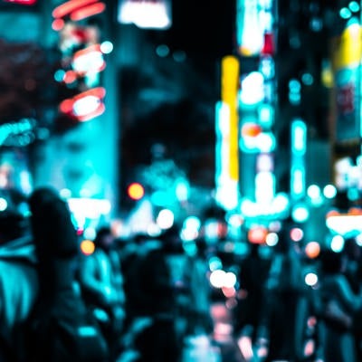 渋谷のネオンと交差点を行き交う通行人（夜間）の写真