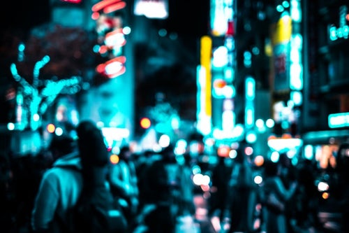 渋谷のネオンと交差点を行き交う通行人（夜間）の写真