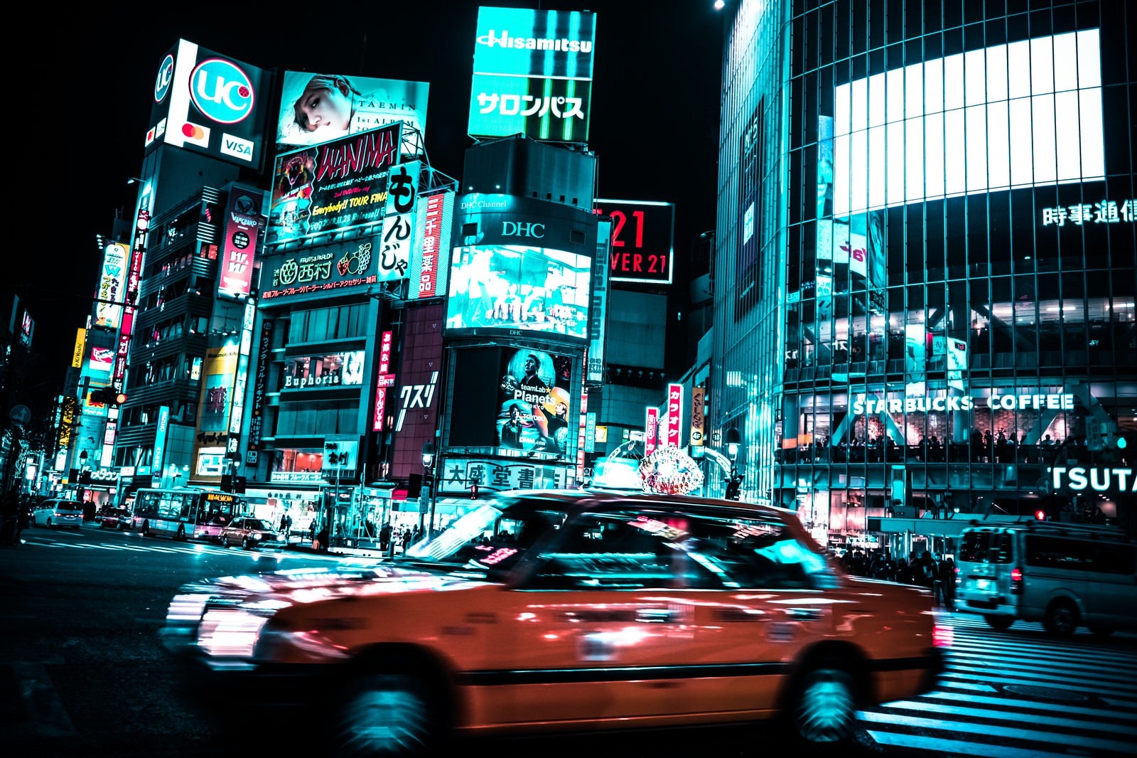 「渋谷のスクランブル交差点を走り抜ける車」の写真