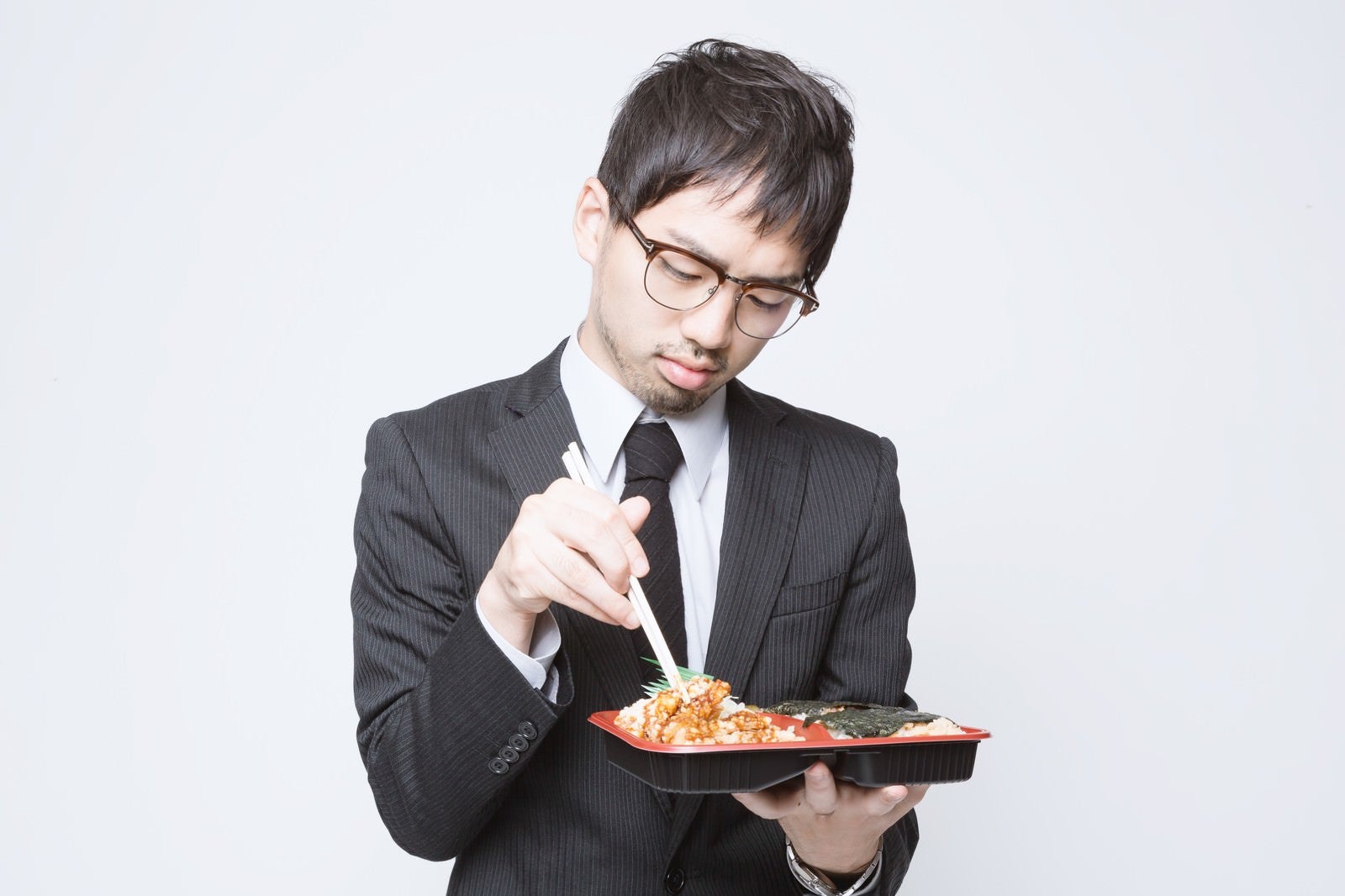「のり弁当を食べる会社員」の写真［モデル：ひろゆき］
