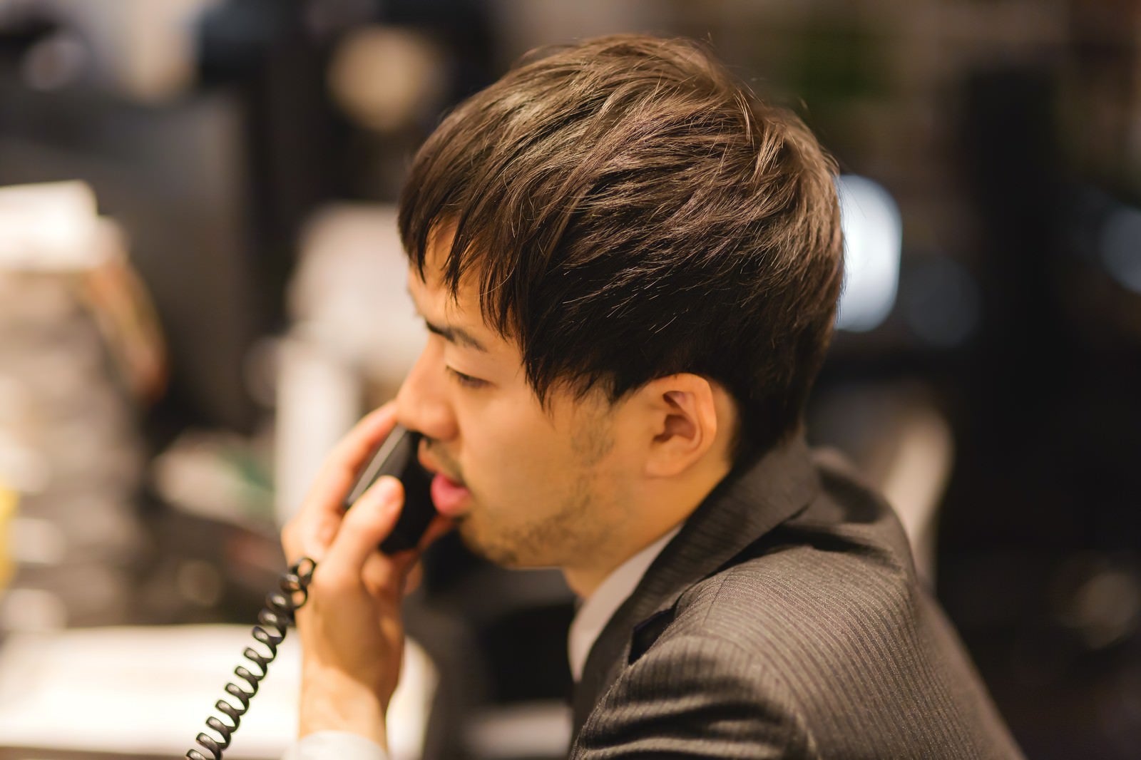 「オフィスで電話対応中のビジネスマン」の写真［モデル：ひろゆき］