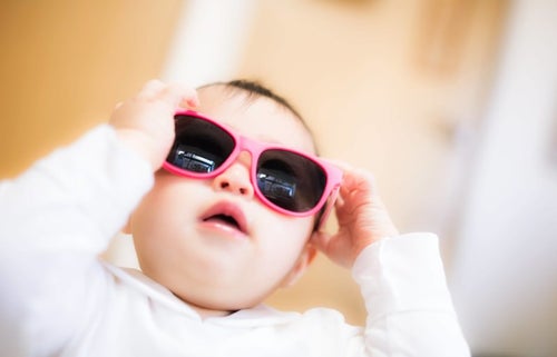 大きなサングラスをかける赤ちゃんの写真