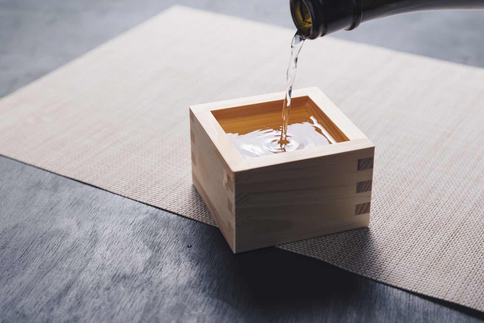 「升に注ががれる日本酒の様子」の写真
