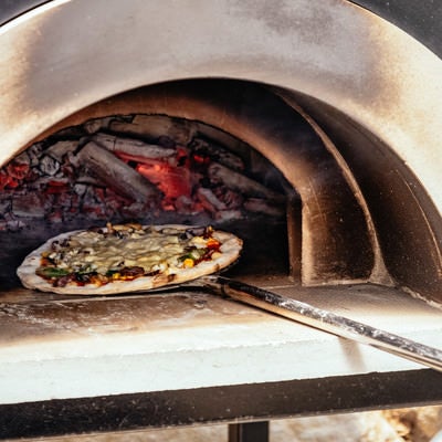 釜から取り出されるピザの写真