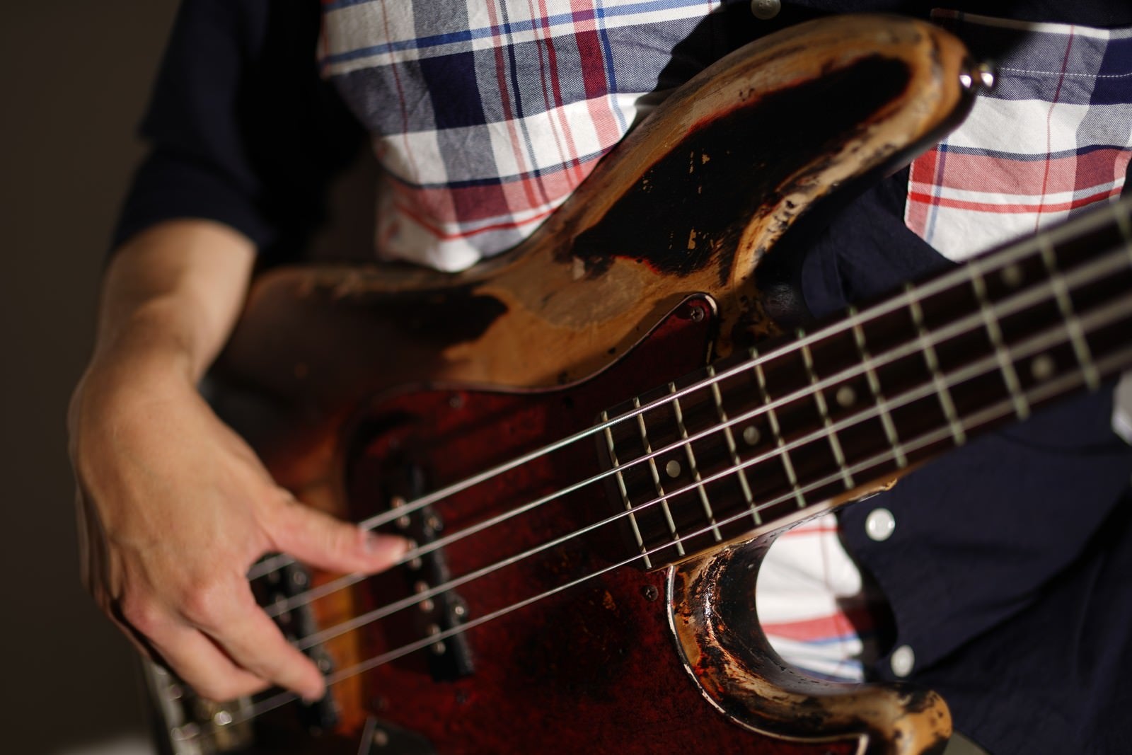 「ベースを演奏する男性の手元」の写真