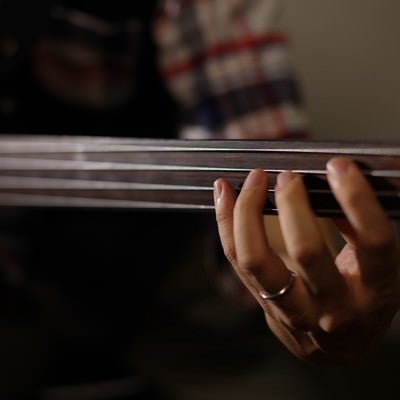 ウッドベースの4弦を抑える指の写真