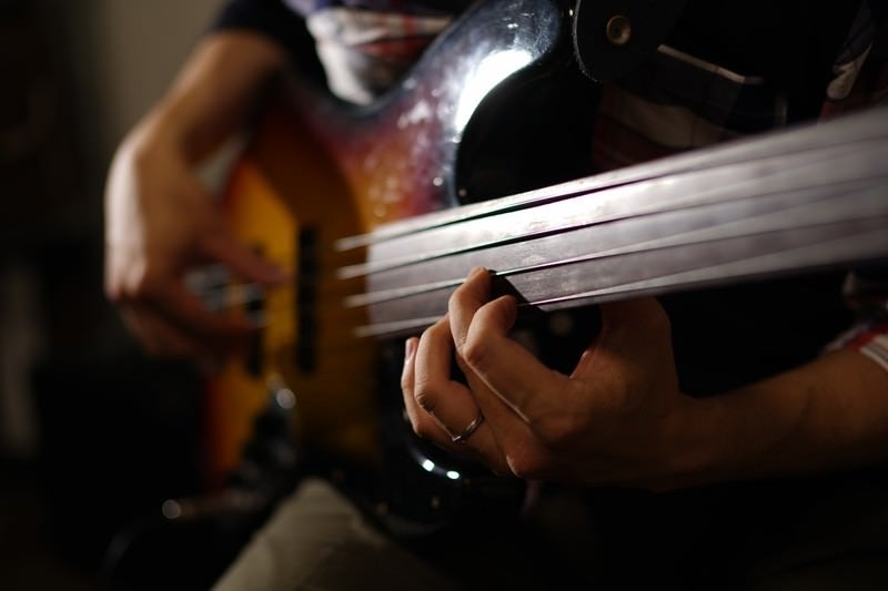 ベースギターを弾く男性ミュージシャンの写真