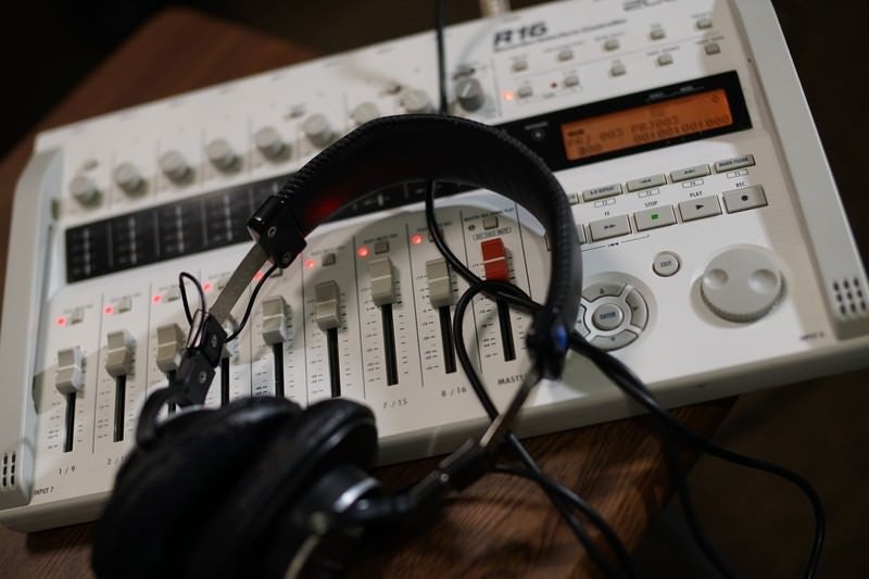 Music production scene with professional multi-track recorder and monitor headphones