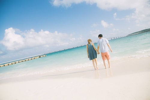 来間大橋を見ながら、前浜ビーチで手を握りあうカップルの写真