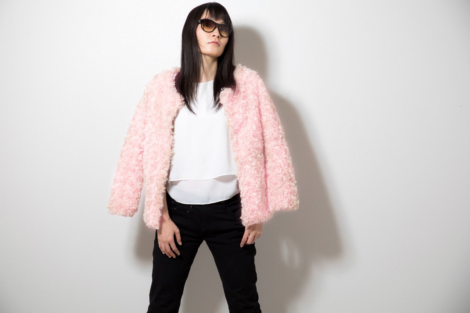 「ピンク色のプードルコートを着た女性」の写真［モデル：たけべともこ］