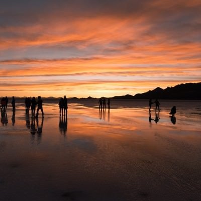 美しい夕暮れのウユニ塩湖と観光客のシルエットの写真