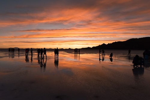 美しい夕暮れのウユニ塩湖と観光客のシルエットの写真