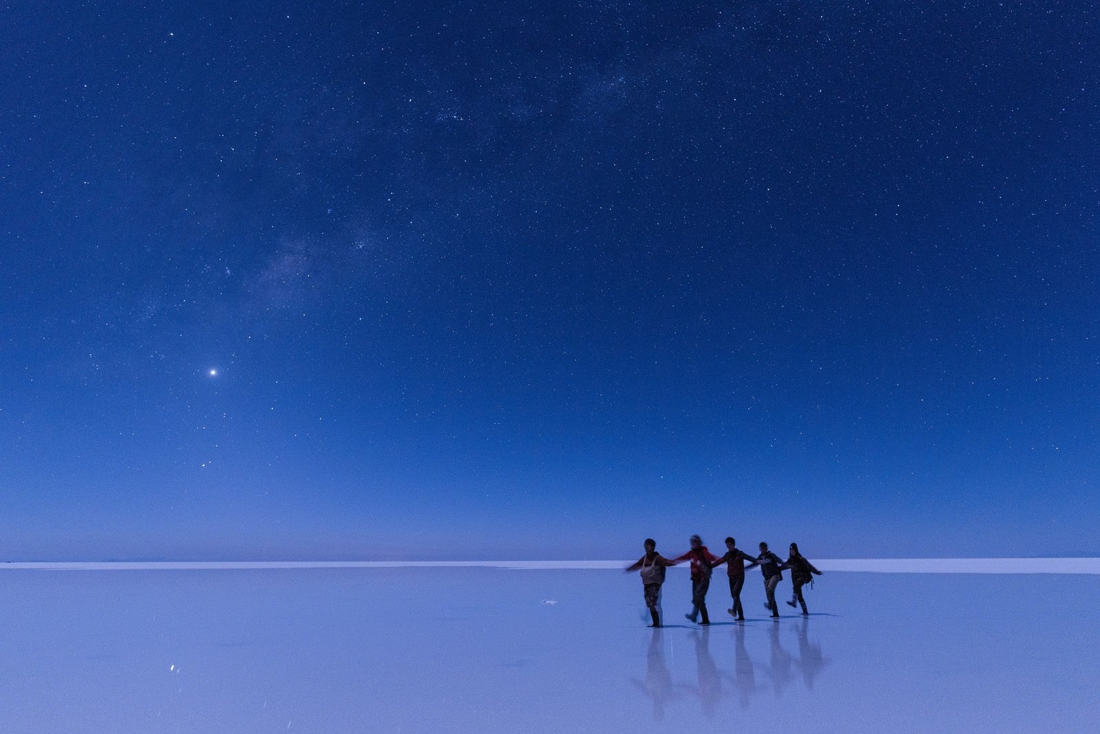 「ウユニ塩湖で星空ツアーを楽しむ観光客」の写真