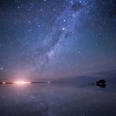 星空が反射するウユニ塩湖の雨季の写真