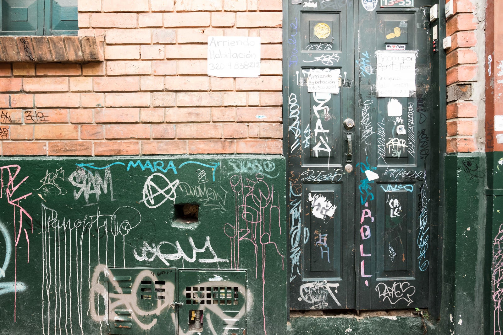 「落書きされた民家の扉と壁（コロンビア）」の写真