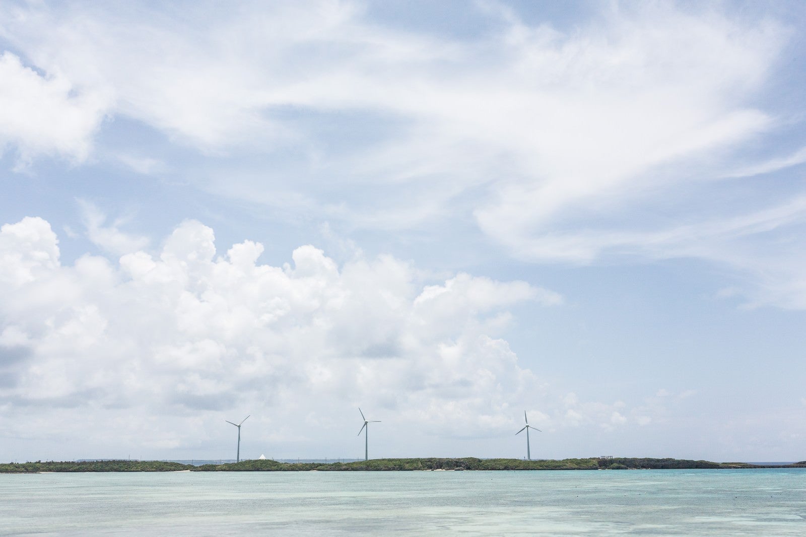 「透き通る海と風力発電」の写真