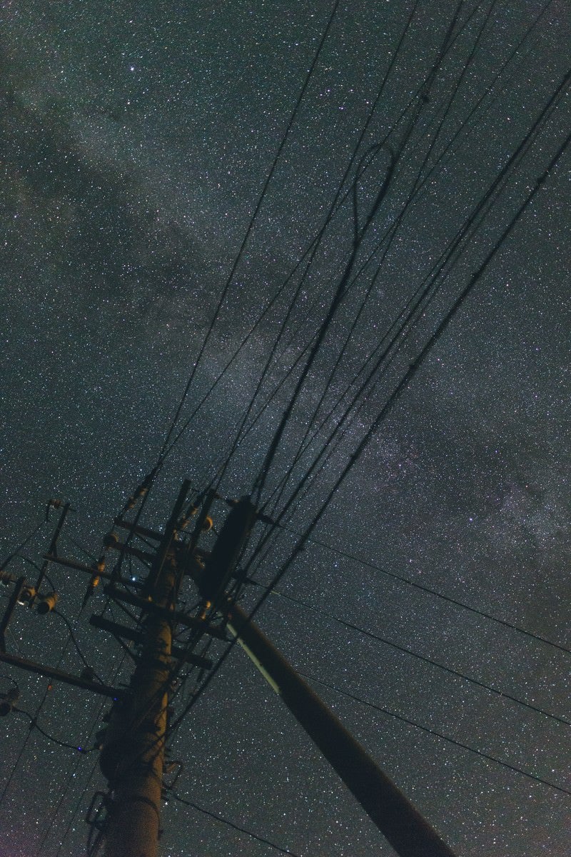 「電柱のシルエットと輝く星空」の写真