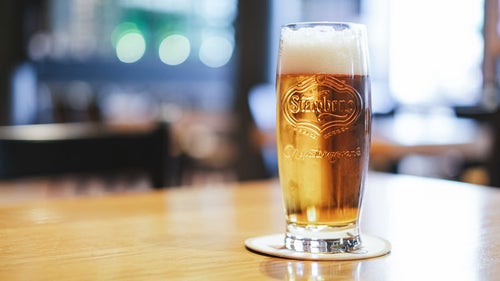 テーブルの上に置かれたグラスビール（チェコ共和国・ブルノ）の写真