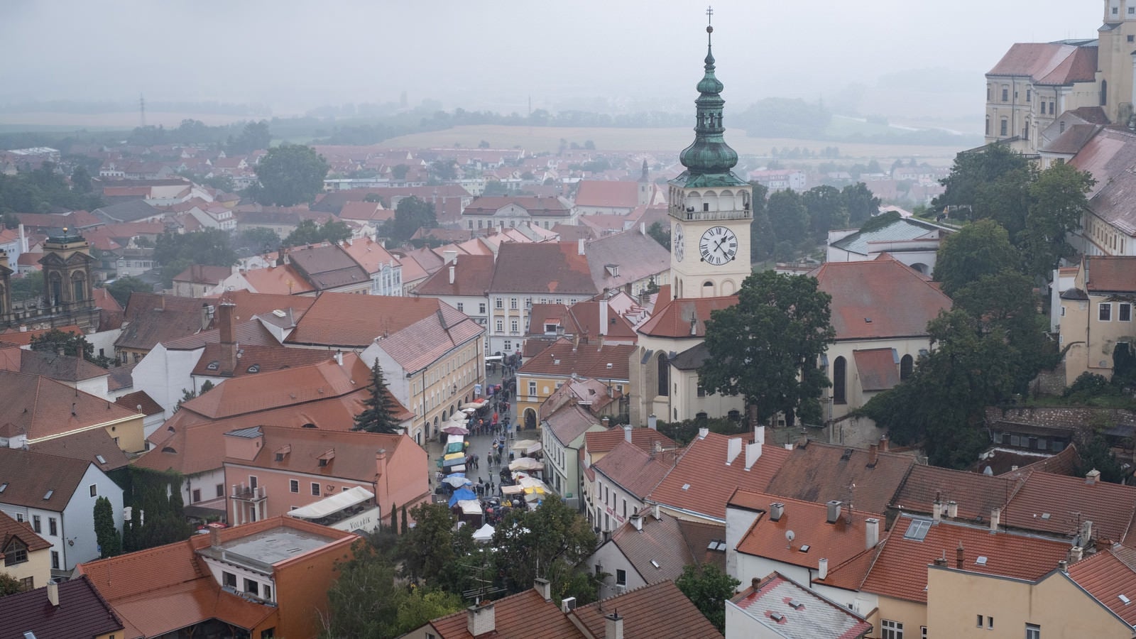 「赤茶に統一された屋根と時計台（チェコ共和国・ミクロフ）」の写真