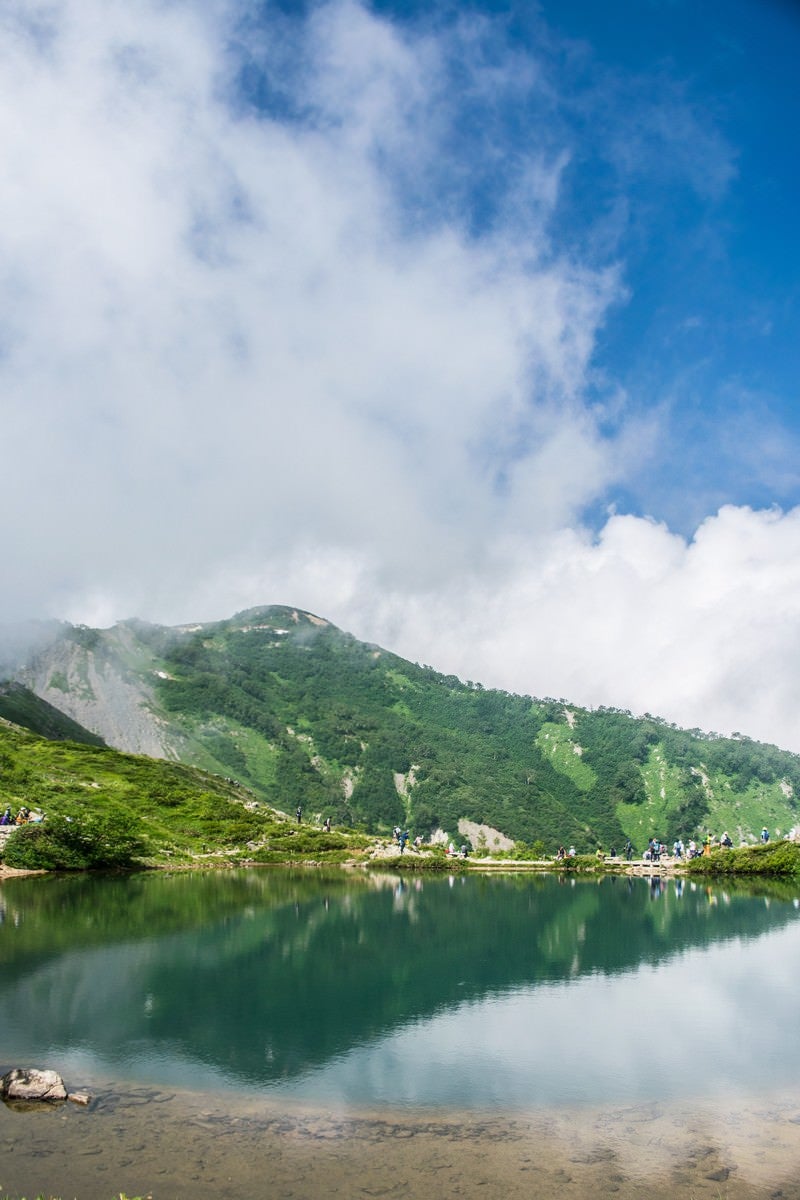 「沸き立つ雲と湖面に映る山」の写真
