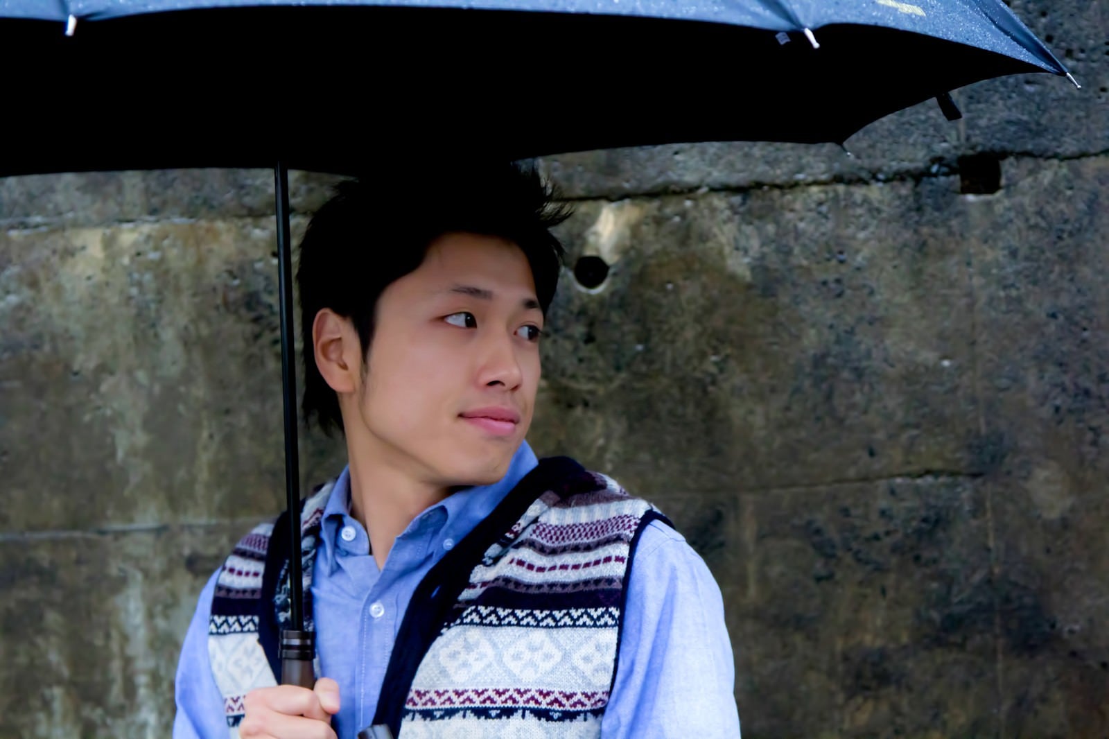 「傘を持ち振り返る男性」の写真［モデル：恭平］