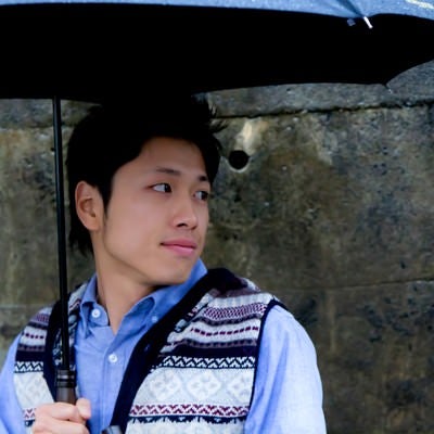傘を持ち振り返る男性の写真