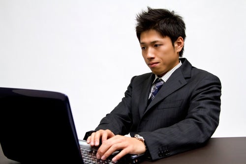 ノートパソコンで作業中のビジネスマンの写真