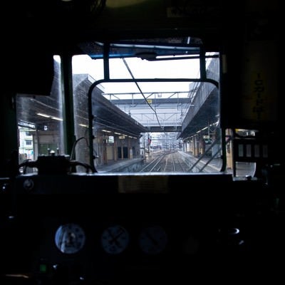 電車の運転席と窓越しのホームの写真