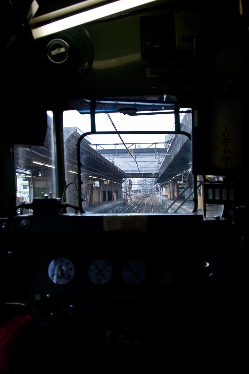 「電車の運転席と窓越しのホーム」の写真