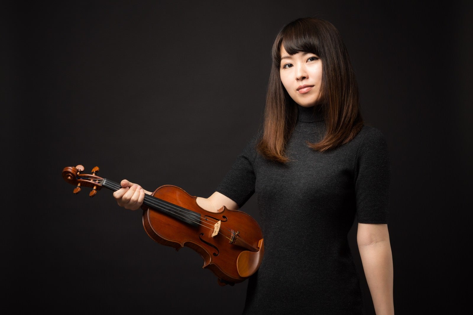 「ヴァイオリンを片手にこちらをみる女性」の写真［モデル：yukiko］