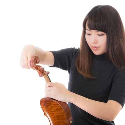 ヴァイオリンの弦を張り替える女性の写真