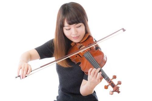 優雅にヴァイオリンを弾く女性の写真