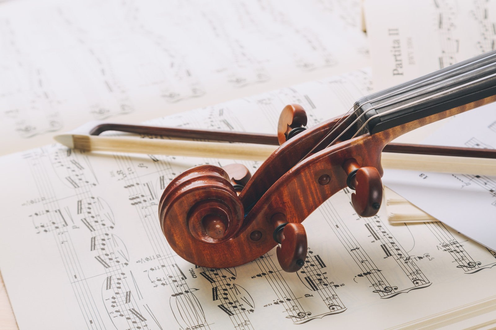 「楽譜の上のヴァイオリンのネックと弓」の写真