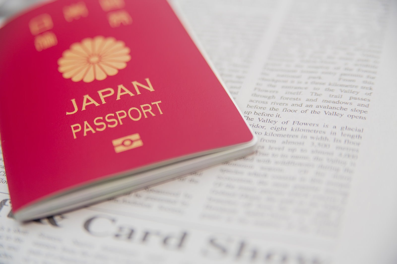 「パスポートと英文の新聞 | フリー素材のぱくたそ」の写真