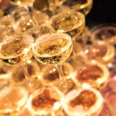 シャンパンタワーのグラスに注がれる泡立つシャンパンの写真