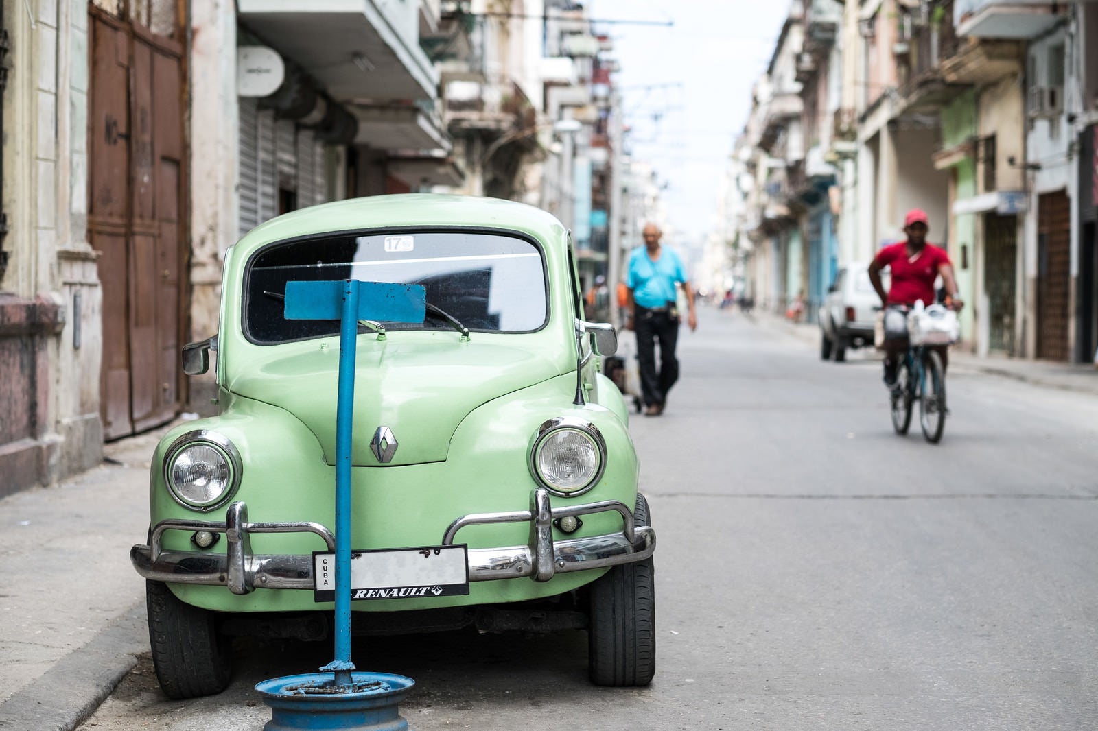 「ハバナの街並みと停車するクラシックカー」の写真